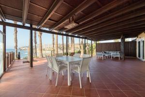 a dining room with a table and chairs on a patio at Suite Altamar, 2 Bedroom - by Gestión Vacacional Canarias in Playa del Aguila