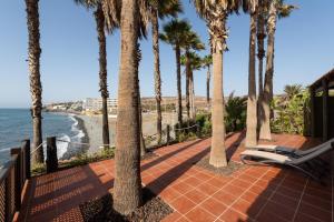 a patio with palm trees and a chaise lounge at Suite Altamar, 2 Bedroom - by Gestión Vacacional Canarias in Playa del Aguila