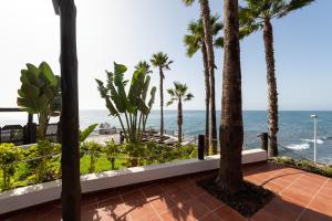 a balcony with palm trees and the ocean at Suite Altamar - by Gestión Vacacional Canarias in Playa del Aguila