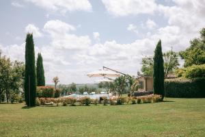 einen Garten mit einem Sonnenschirm und einem Haus in der Unterkunft La Monteduccia in Ostra Vetere