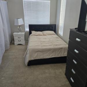 a bedroom with a bed and a dresser and a television at Furnished room in big home in Las Vegas