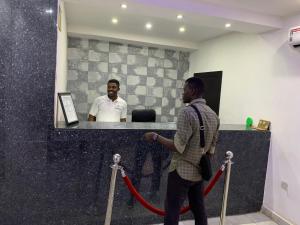 a man walking down a red ribbon gmaxwell gmaxwell gmaxwell at Pulville Boulevard Hotel in Suru Lere