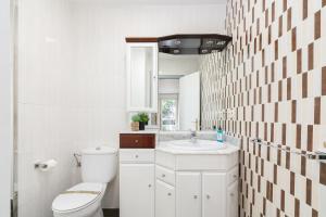 a white bathroom with a toilet and a sink at Cómodo y económico by CABANA Rentals in Vigo