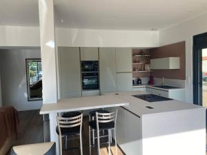 a kitchen with a island with bar stools at Les Ecureuils in Pougues-les-Eaux