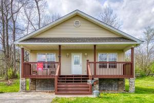 a small yellow house with a front porch at Lee's Creekside in Pigeon Forge