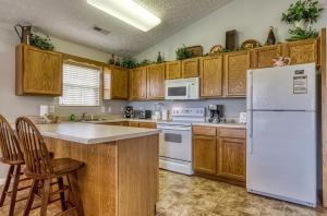 a kitchen with wooden cabinets and a white refrigerator at Lee's Creekside in Pigeon Forge