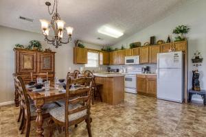 a kitchen with a table and a white refrigerator at Lee's Creekside in Pigeon Forge +27 photos