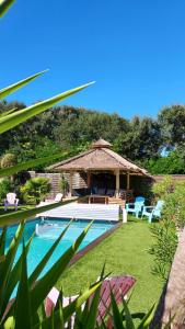 a swimming pool with a gazebo and chairs next to at Villa Océan Labenne Plage in Labenne