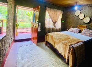 een slaapkamer met een bed in een kamer met ramen bij Alkebulan Farm House in Moshi