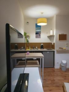 eine Küche mit Tisch und Arbeitsplatte in der Unterkunft L'îlot du Val d'Europe à 2 minutes du RER et à 5 minutes de Disneyland in Montévrain