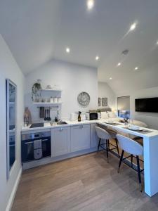 a kitchen with white cabinets and a table and chairs at Tithe Cottage in Tamworth