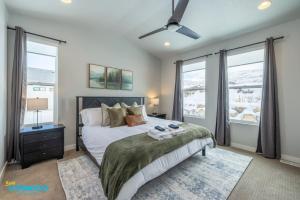 1 dormitorio con 1 cama, ventilador de techo y ventanas en Brand New Heber Hideaway, en Daniel