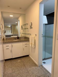 un bagno con lavandino e doccia con specchio di Chic hotel suite in fabulous Meireles Fortaleza with WiFi, fitness room a Fortaleza