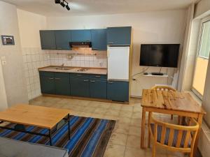 a kitchen with blue cabinets and a table and a refrigerator at Ruhige Ferienwohnung mit Privatparkplatz in Sagard