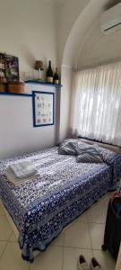 Una cama sentada en una habitación con ventana. en Cri Cri, en Marina Grande