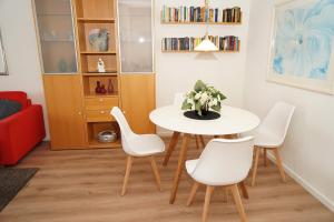 a dining room with a white table and chairs at Ferienwohnung zur Hafenseite _ 200 in Damp