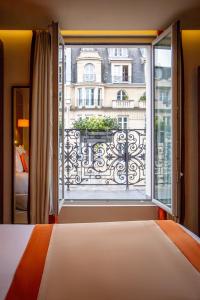 a bedroom with a bed and a large window at Hôtel La Bourdonnais by Inwood Hotels in Paris