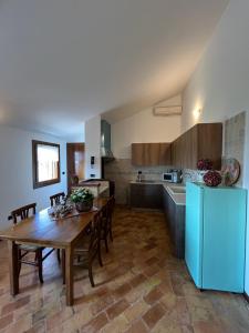 a kitchen with a wooden table and a blue refrigerator at Casa vacanze Pierangela in Susegana