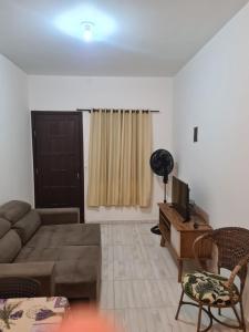 a living room with a couch and a television at Casa de temporada in Guaratuba