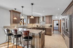 a kitchen with wooden cabinets and a island with bar stools at Spacious Secluded 2 Acres Remodeled Walk To Willit in Basalt