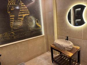 a bathroom with a stone sink and a mirror at Pyramids Rafif Hotel in Cairo