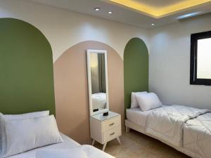 a bedroom with two beds and a mirror at Pyramids Rafif Hotel in Cairo