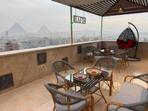 a restaurant with tables and chairs on the roof of a building at Pyramids Rafif Hotel in Cairo
