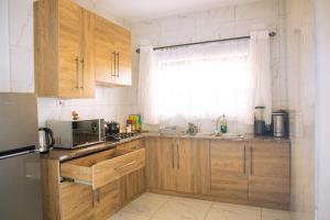a kitchen with wooden cabinets and a microwave at Mineheart Apartments & Boutique Hotel in Nyanda