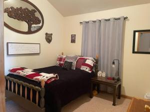1 dormitorio con cama negra y espejo en Stunning Secluded Mtn Getaway, Picturesque Views, en Bordenville