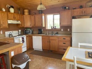 Una cocina con gabinetes de madera y un refrigerador blanco. en Stunning Secluded Mtn Getaway, Picturesque Views, en Bordenville