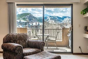 a living room with a couch and a balcony with a view at Spacious Seasons Vacation Home Steps To Lift in Avon