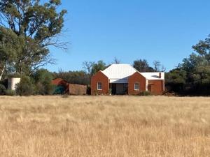 a red house in a field of grass at Kareepoort Guest Farm in Bloemfontein