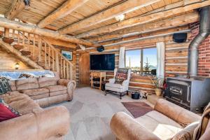a living room with couches and a fireplace in a log cabin at Amazing 3200Sq ft Upgrade Log Cbn GameRoom HotTub in Bordenville