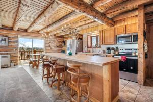 a kitchen with a large island with bar stools at Amazing 3200Sq ft Upgrade Log Cbn GameRoom HotTub in Bordenville