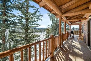 a wrap around deck with a view of the snow covered trees at Amazing 3200Sq ft Upgrade Log Cbn GameRoom HotTub in Bordenville