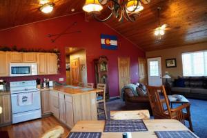 a kitchen and living room with red walls at Fox Hole Serene Secluded Private Cabin Hot Tub in Bordenville +35 photos