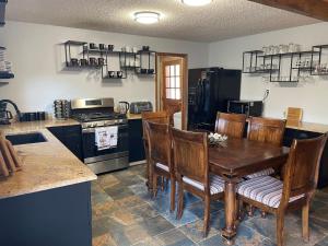 a kitchen with a wooden table and wooden chairs at Cozy Mountain Cabin W Hot Tub Breathtaking Views in Alma +30 photos