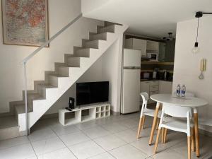 a kitchen with a table and a staircase with a television at Freire Suites in Buenos Aires