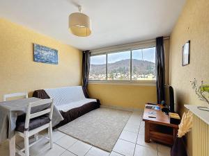 a living room with a couch and a window at Appartement Royat 2 pers Romeuf in Royat