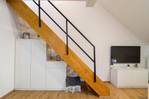 a living room with a staircase and a tv at Flexible SelfCheckIns 71 - Zagreb - New - Center - 50m from the Main Square in Zagreb