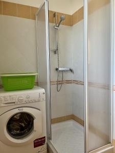 een wasmachine in een badkamer met een douche bij Yellow Beachfront house 60 m by Salento Prime in Marina di Pescoluse +11 foto's