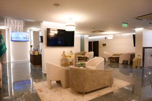 a lobby with chairs and a tv on a wall at فندق فيوليت الفندقية Violet Hotel in Yanbu