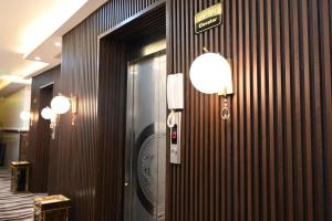 a lobby with two lights on a wooden wall at فندق فيوليت الفندقية Violet Hotel in Yanbu