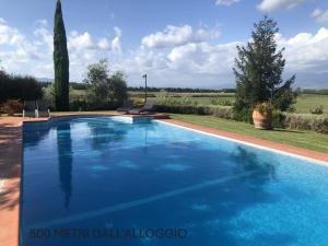 a swimming pool with blue water in a yard at Il campanile in Cavriglia