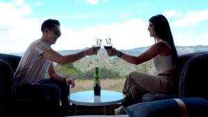 a man and a woman holding glasses of wine at Glamping Waná in Sutatausa