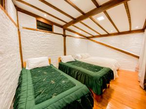 a bedroom with two beds in a room with wooden floors at Chuza Longa Home in Guamote +78 photos