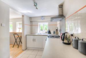 a kitchen with white cabinets and a counter top at Finest Retreats - Town End Barn in Buxton