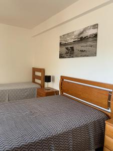 a bedroom with two beds and a picture on the wall at Garden Guest House in Rogil