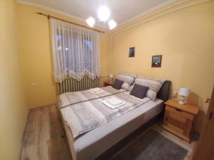 A bed or beds in a room at Sándor Apartman