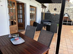 drewniany stół i krzesła na patio w obiekcie Villa Adel 56, private heated pool, parking w mieście Playa Blanca +35 zdjęć